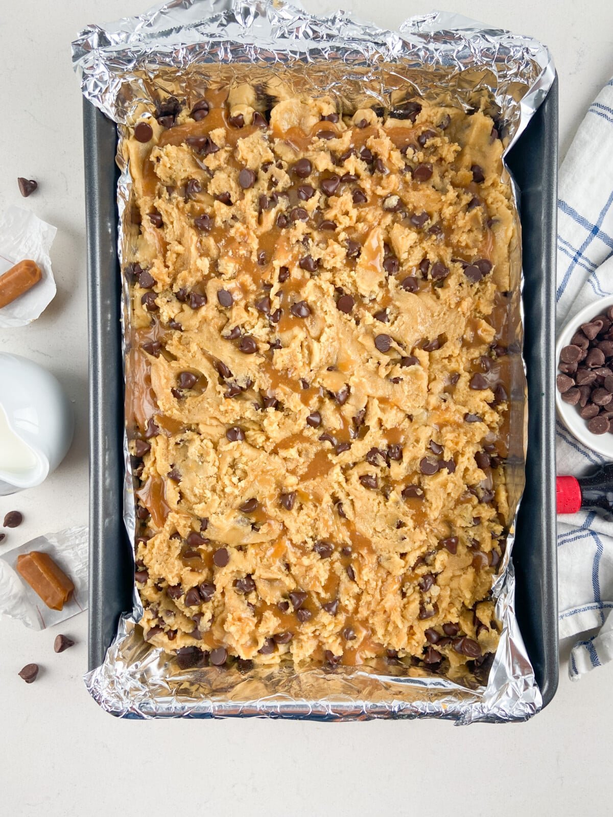 cookie bars in foil lined pans before baking.