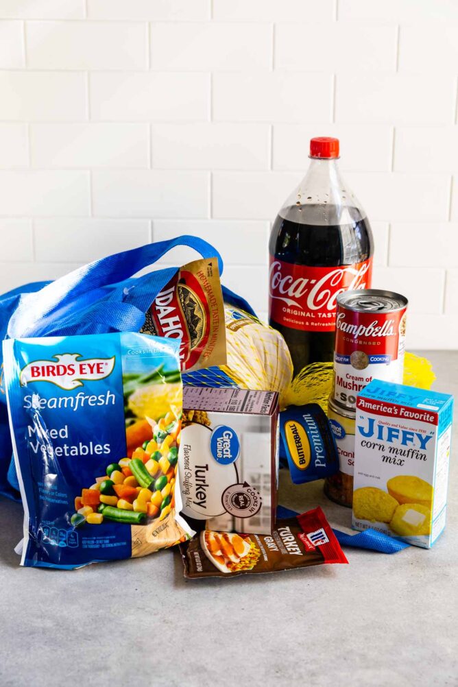 Walmart bag with turkey, coke, soup, muffin mix, vegetables and other groceries