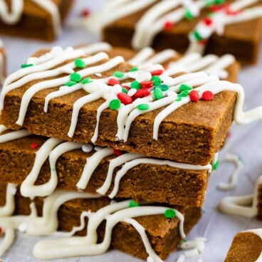 Three gingerbread cookie bars decorated for the holidays and stacked on top of eachother