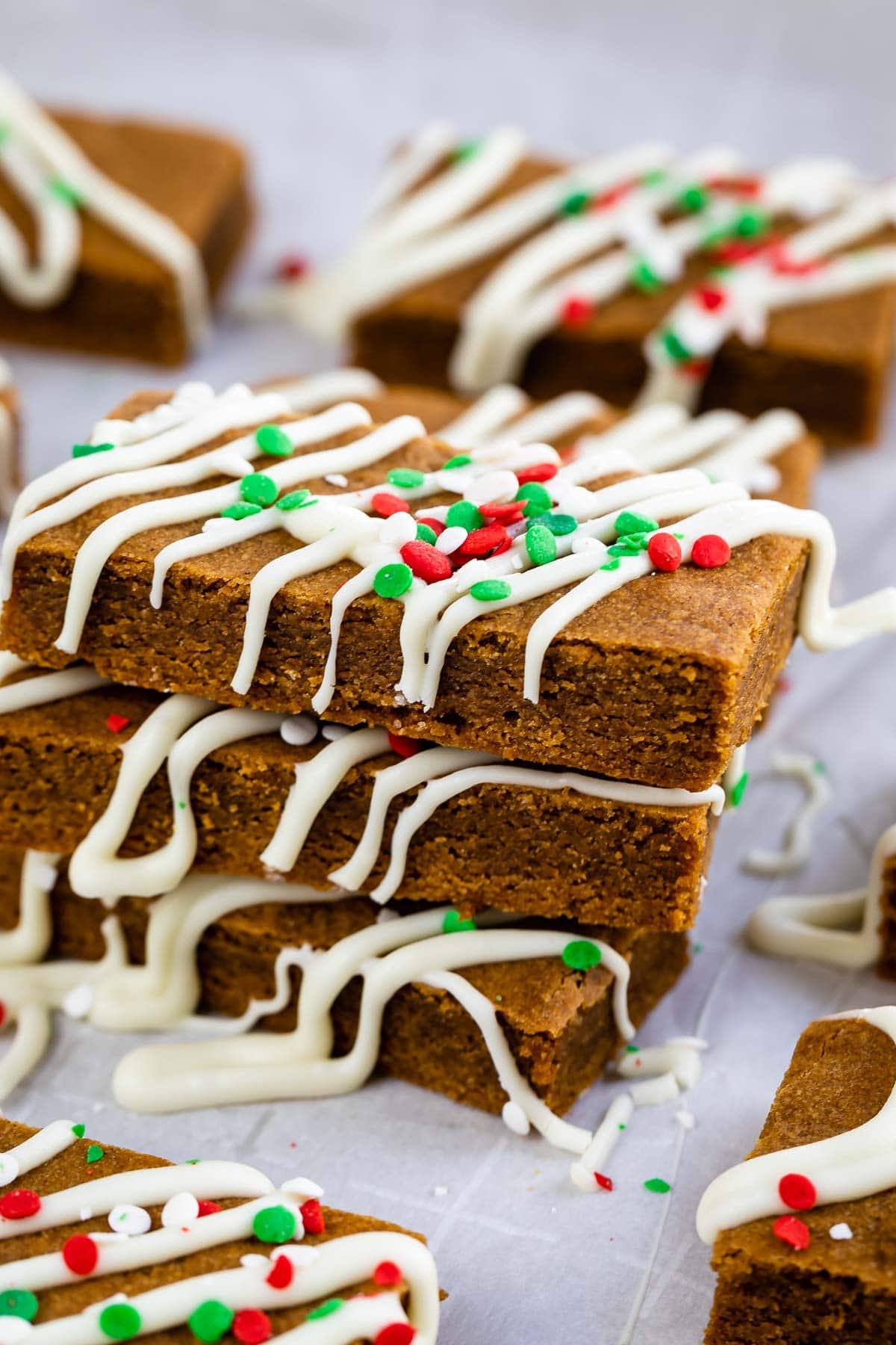 Three gingerbread cookie bars decorated for the holidays and stacked on top of eachother