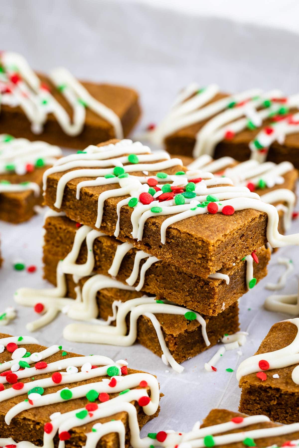 Three gingerbread cookie bars decorated for the holidays and stacked on top of eachother