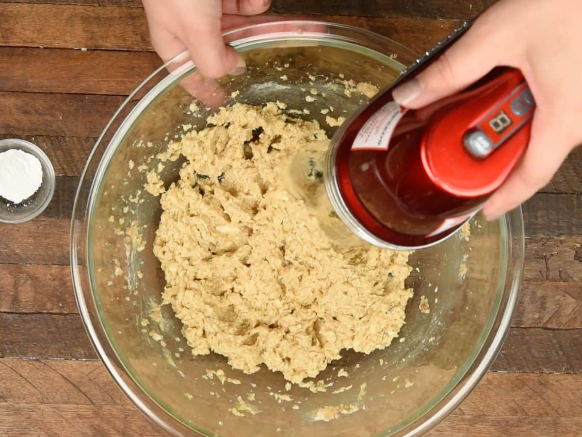 mixer mixing dough in large bowl.