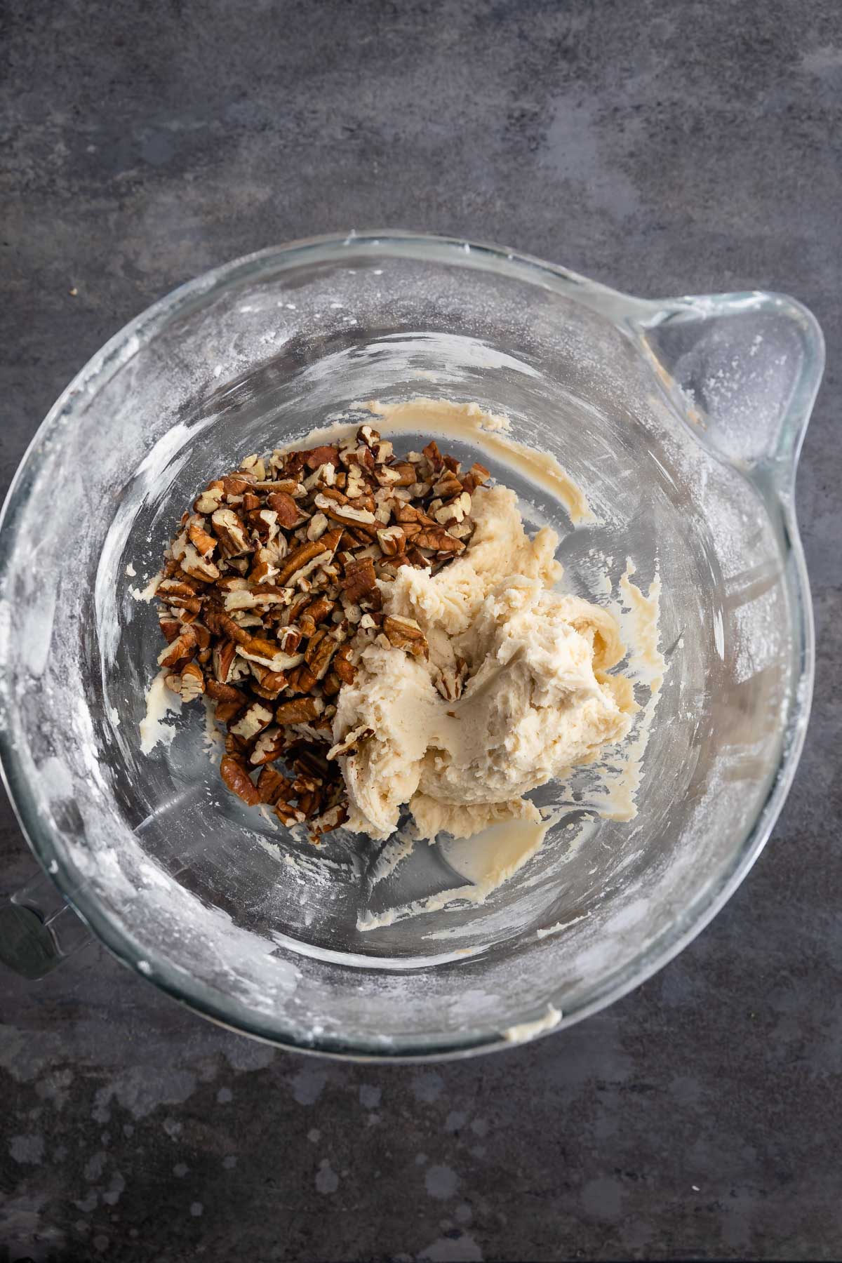 shortbread dough with pecans in glass mixing bowl.