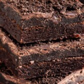 Stack of three Oreo truffle brownies with Oreos around them and recipe title on top of image