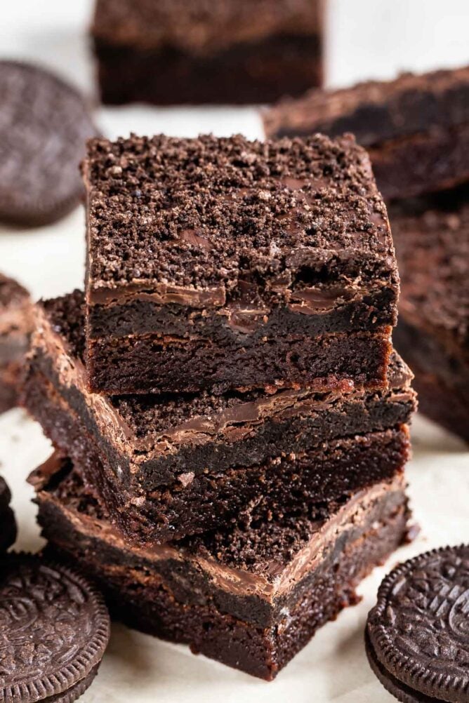 Stack of three Oreo truffle brownies with Oreos around them