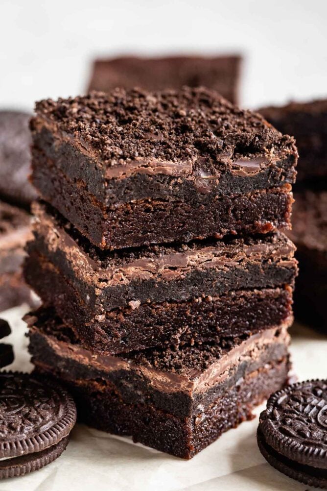 Stack of three Oreo truffle brownies with Oreos around them