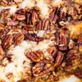 Pecan pie cobbler in a white baking dish with corner piece missing with recipe title on top of image