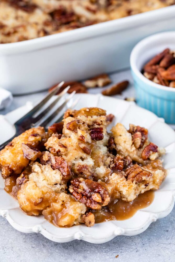 Pecan pie cobbler on a white scalloped dish