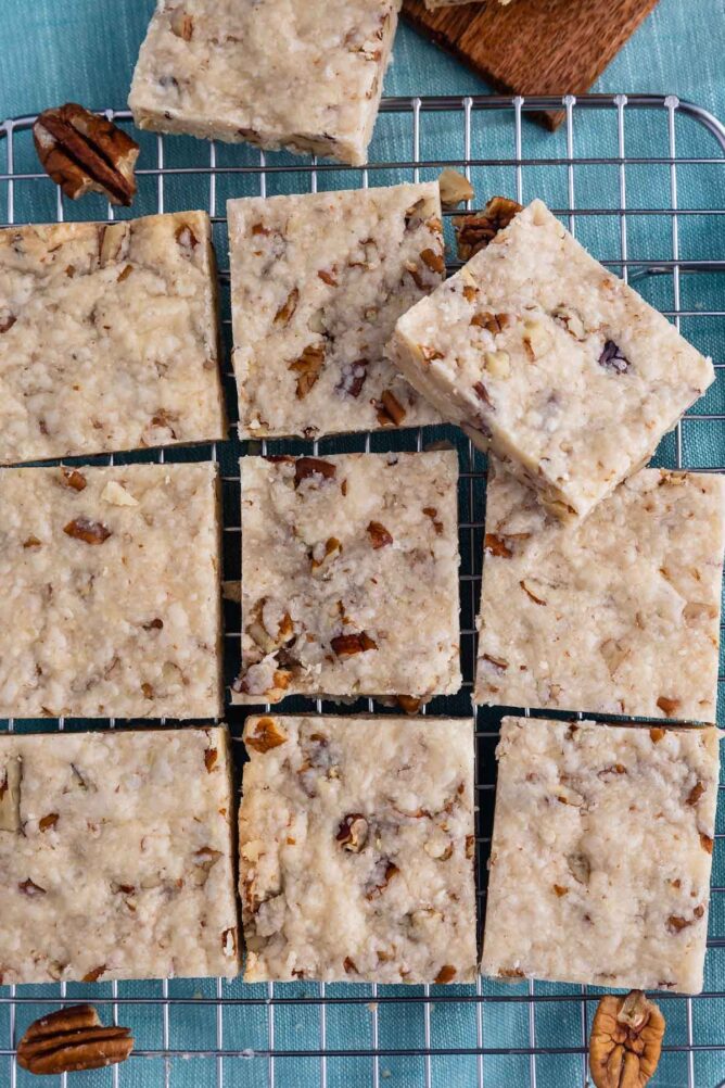 Overhead shot of pecan shortbread cookies cut into squares on a metal cooling rack