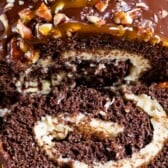 Overhead shot of caramel chocolate turtle cake roll with one slice cut off and recipe title on top of photo