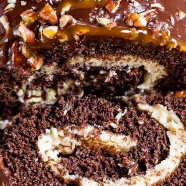 Overhead shot of caramel chocolate turtle cake roll with one slice cut off and recipe title on top of photo