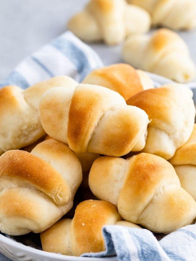 crescent rolls in white bowl with tea towel
