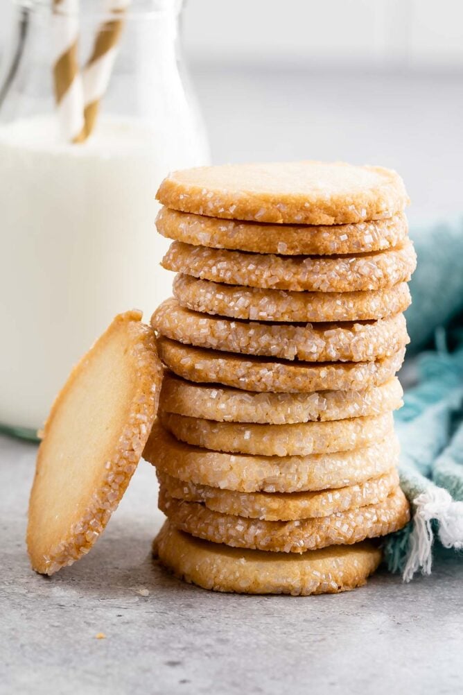 Tall stack of easy butter cookies with one leanin on the side