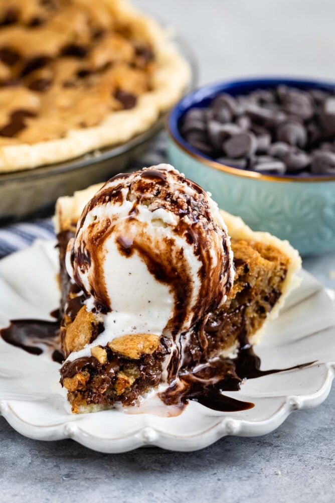 slice of chocolate chip pie on white plate with ice cream