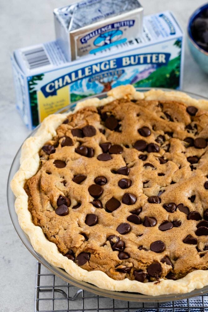 chocolate chip pie in pie plate with butter behind