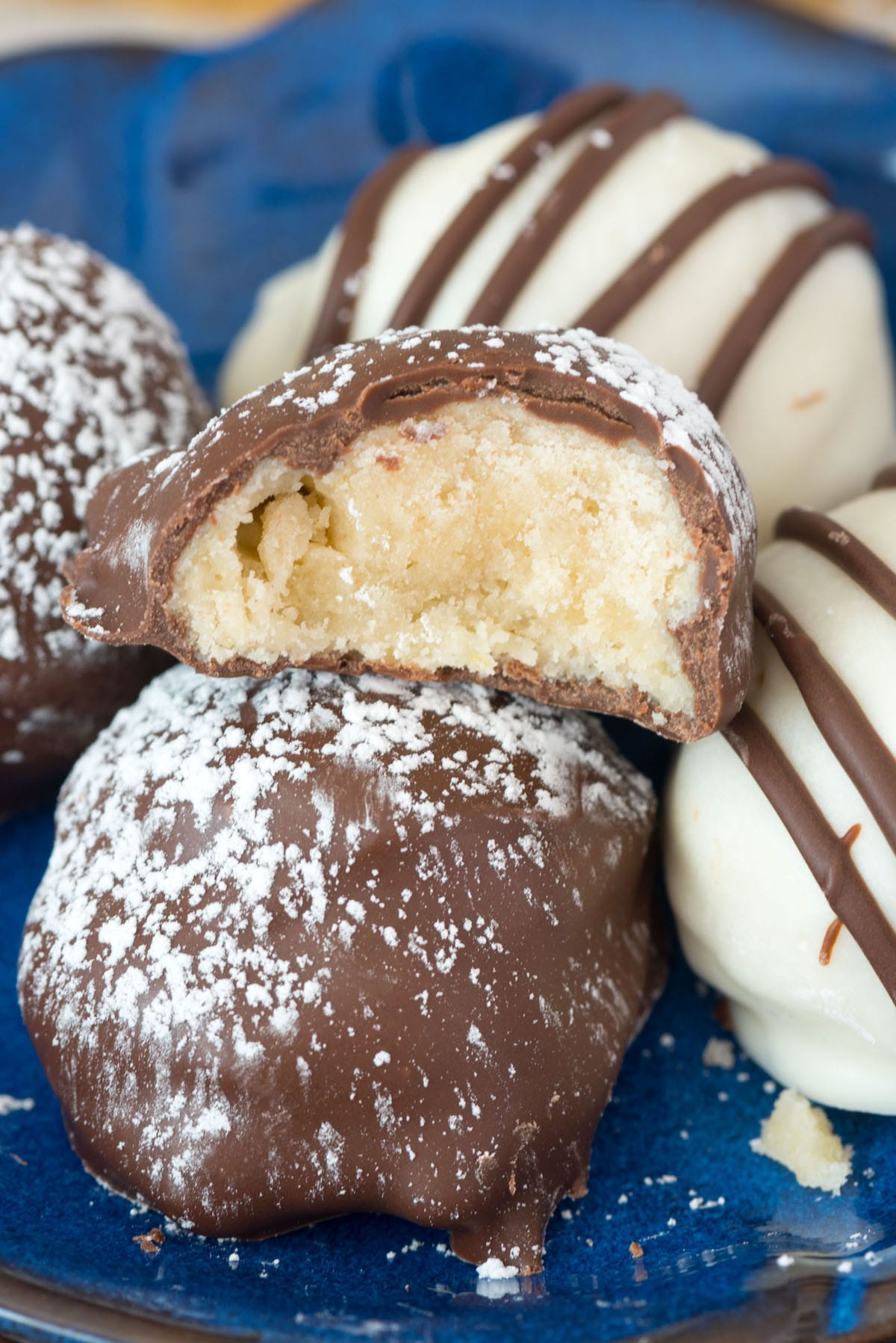 Chocolate dipped cookies on a plate with one bit in half to show inside