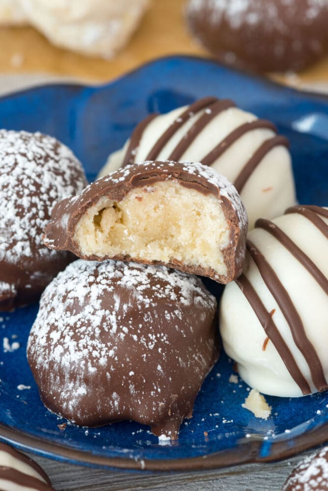 Chocolate dipped cookies on a plate with one bit in half to show inside