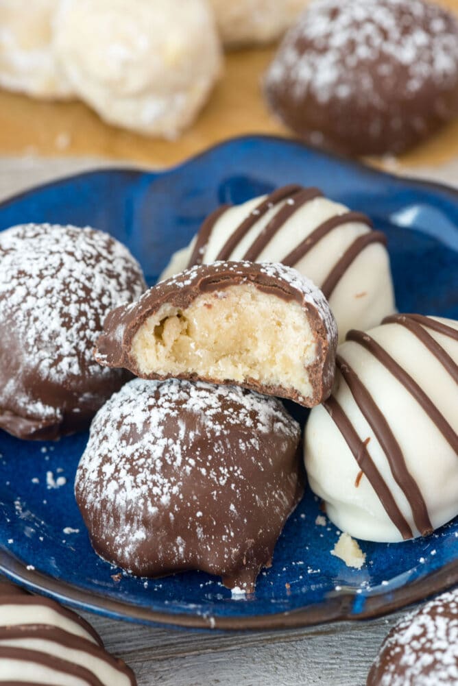 Chocolate dipped cookies on a plate with one bit in half to show inside
