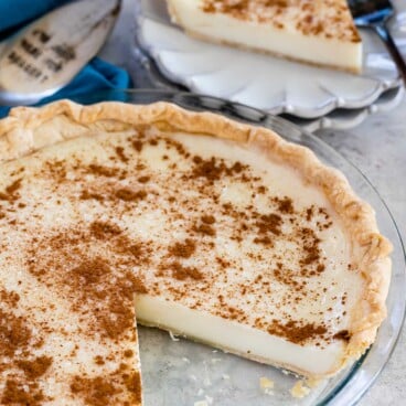 Sugar cream pie with one slice on a plate with fork behind pie