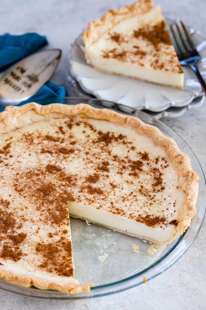 Sugar cream pie with one slice on a plate with fork behind pie