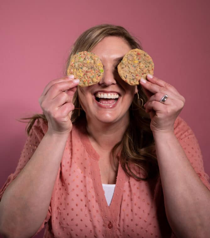 woman holding cookies in front of her eyes