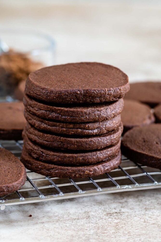 Stack of chocolate shortbread cookies on a metal cooling rack
