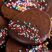 Chocolate shortbread cookies with sprinkles and recipe title on top of image