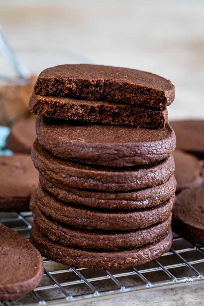 Stack of chocolate shortbread cookies with top cookie cut in half