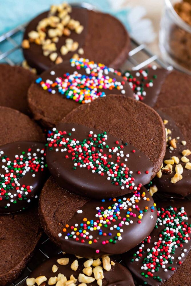 Chocolate shortbread cookies dipped in chocolate and topped with sprinkles and nuts