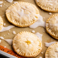 Lemon pie cookies on a silicon baking mat with icing on top