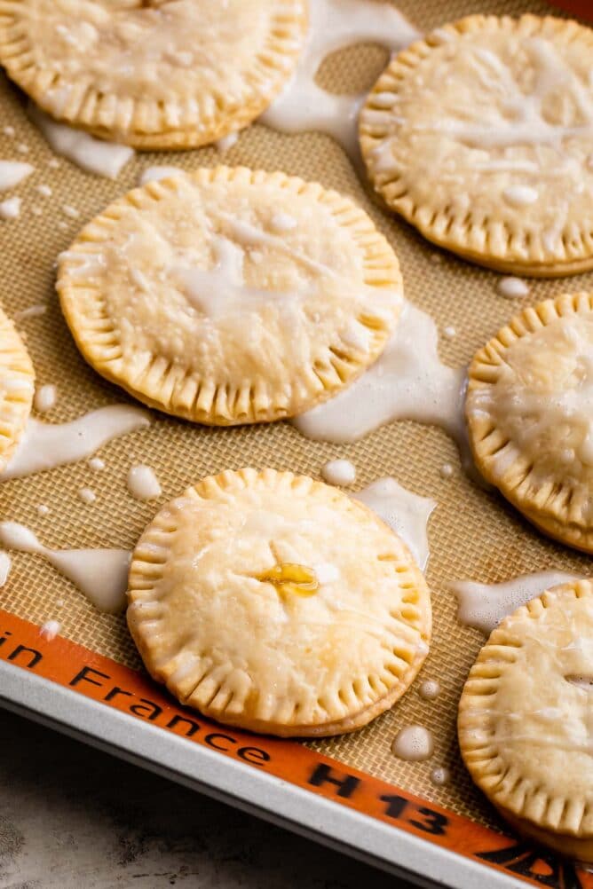 Lemon pie cookies on a silicon baking mat with icing on top