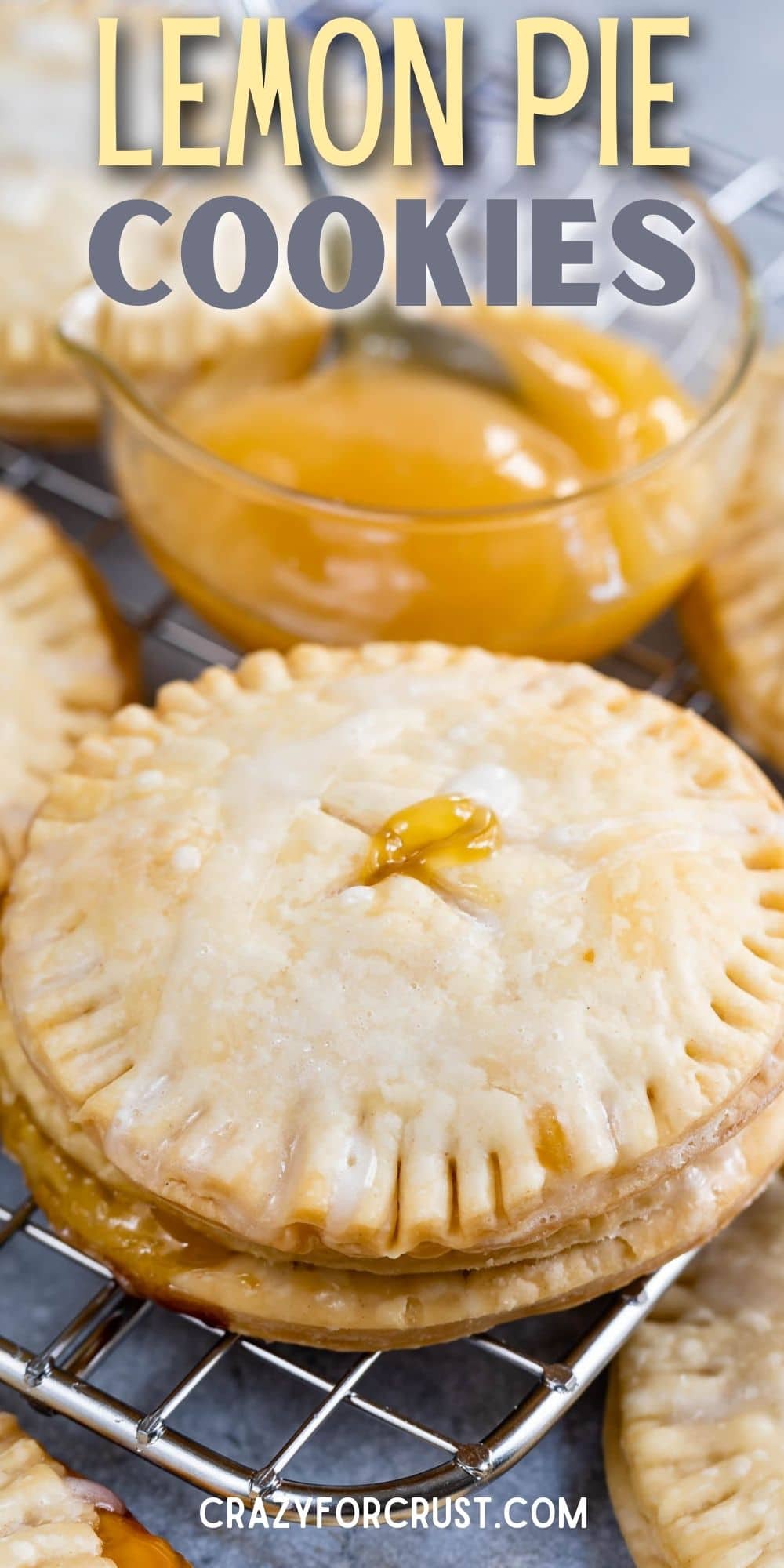 Lemon pie cookies on a metal cooling rack with a small bowl of lemon curd next to them and recipe title on top of image