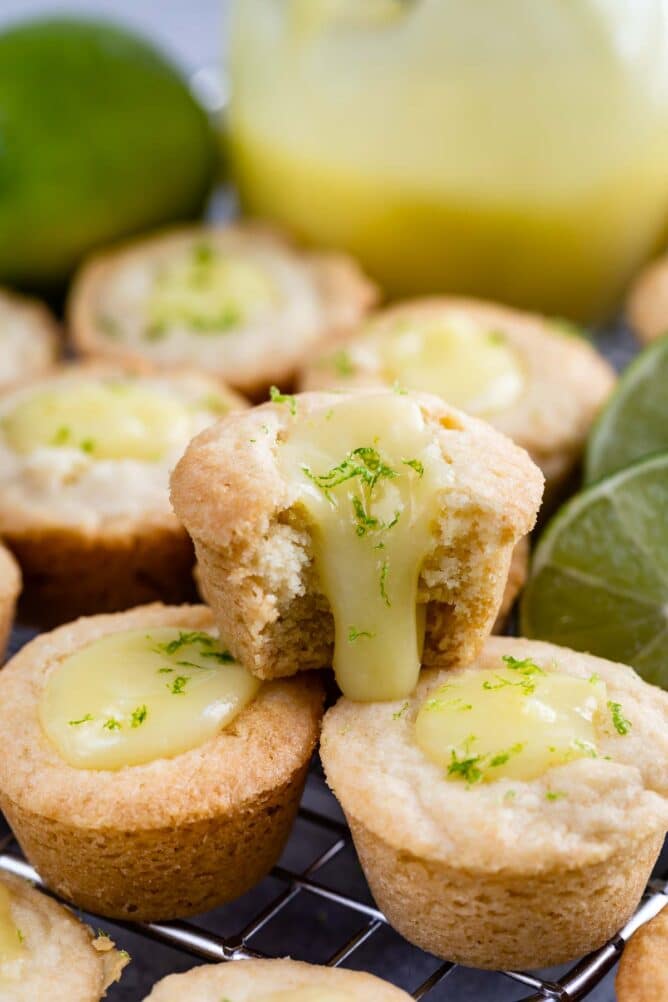 Three lime tarts with top one cut in half to show lime curd inside