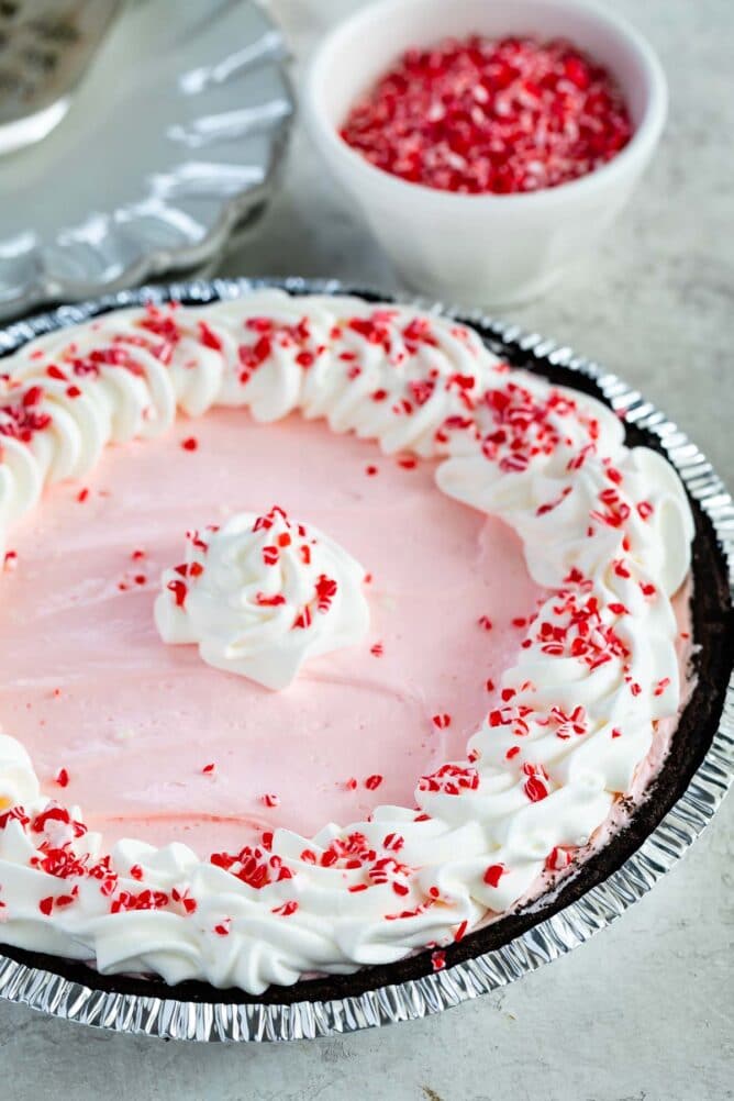 Peppermint pie topped with crushed candy canes and more in the background