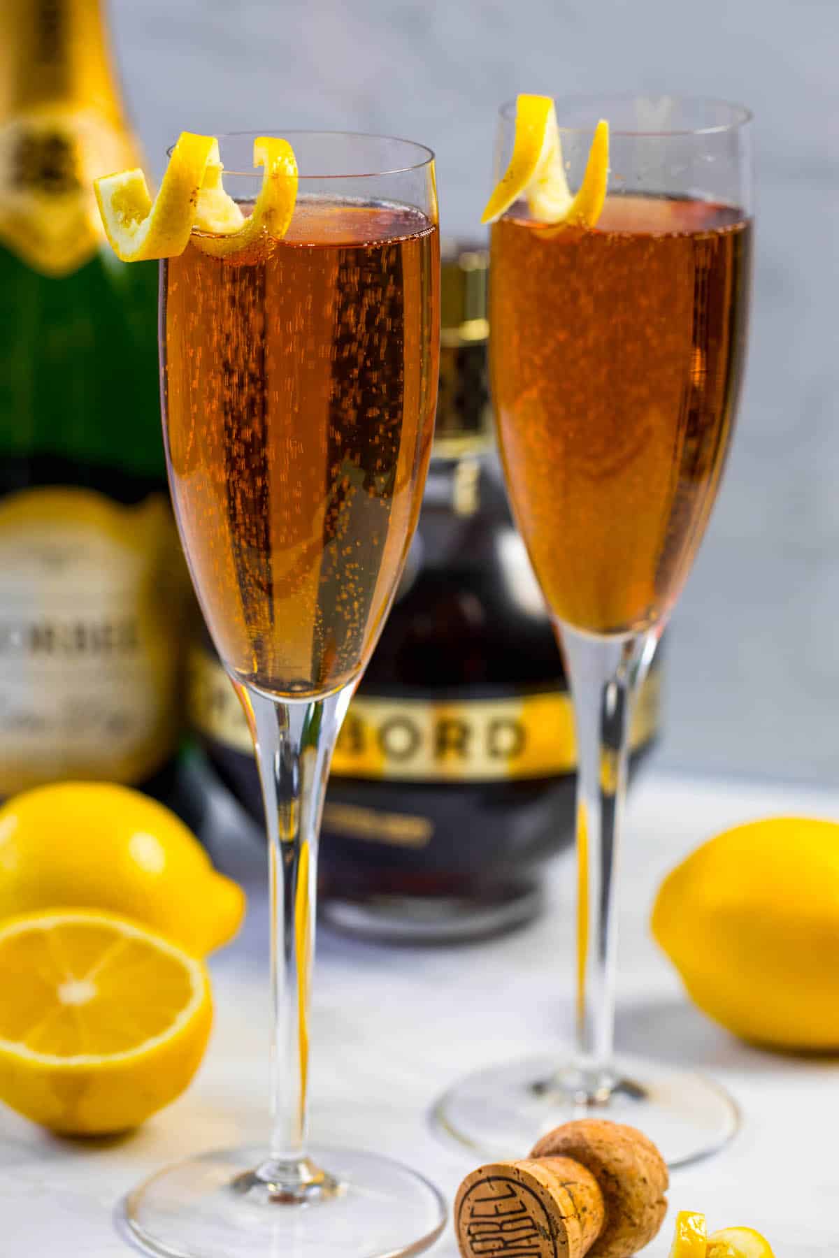 two glasses on Kir royale champagne with a lemon peel on the rim