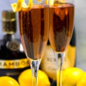 two glasses on Kir royale champagne with a lemon peel on the rim