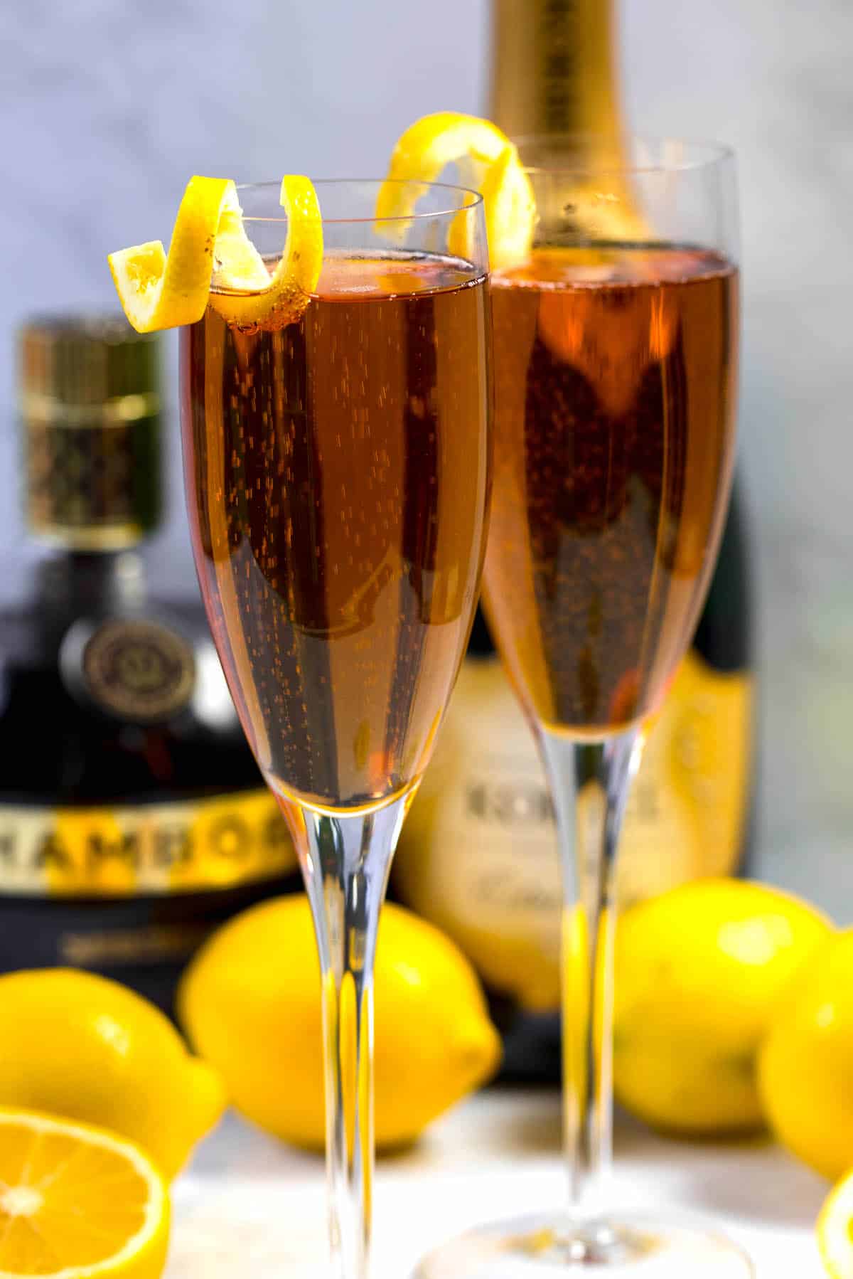 two glasses on Kir royale champagne with a lemon peel on the rim