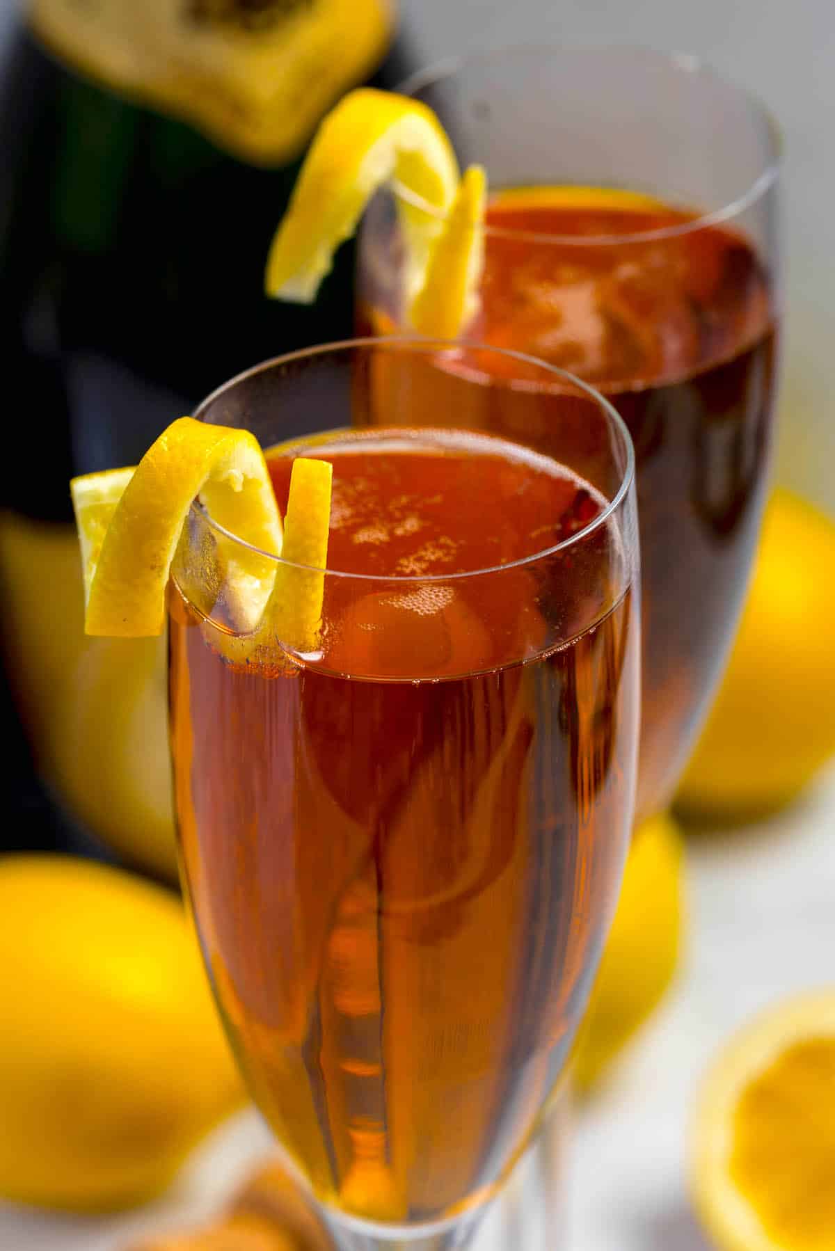 two glasses on Kir royale champagne with a lemon peel on the rim