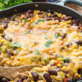 Overhead shot of one pot taco casserole in dish with wooden spoon