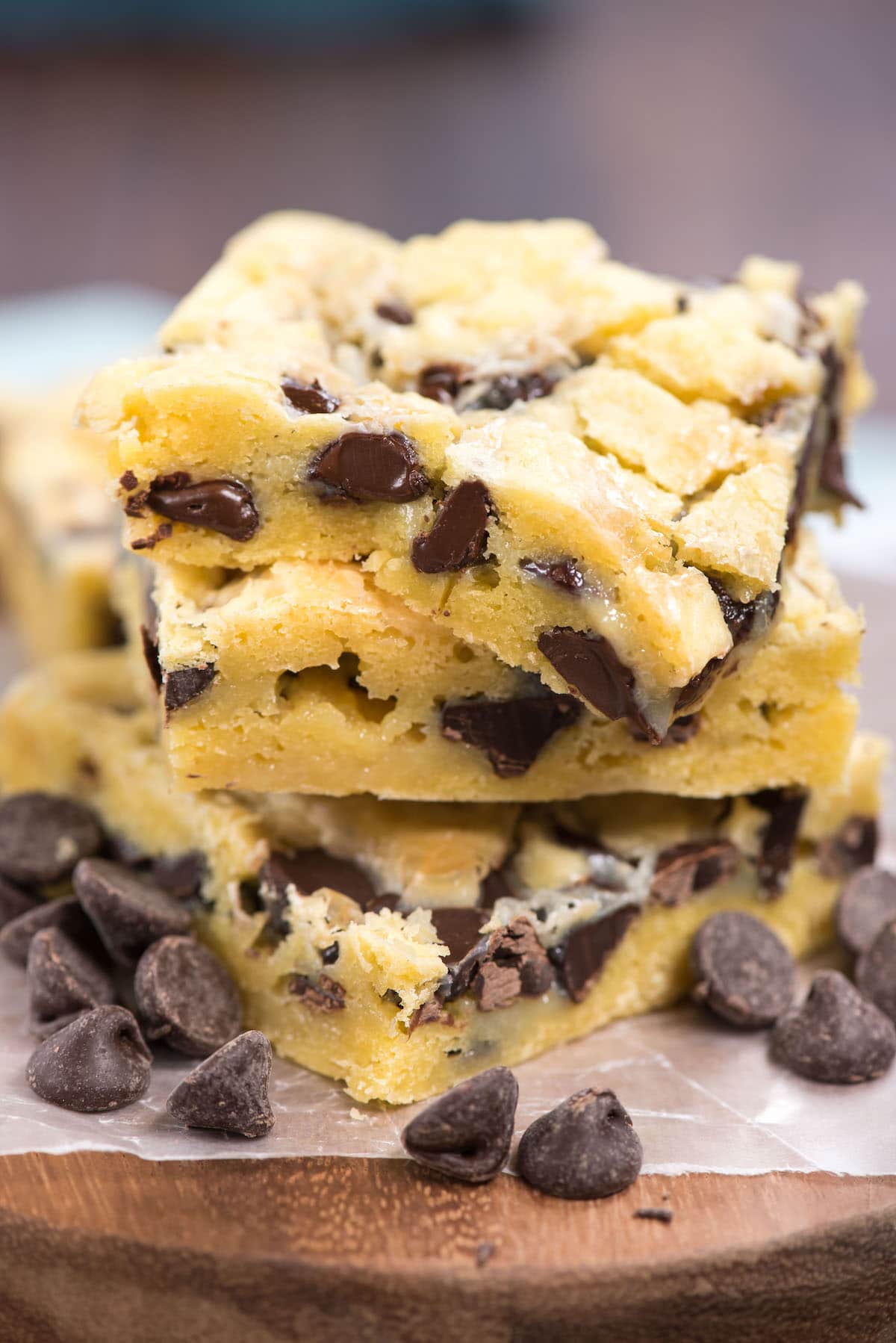 Stack of chocolate chip gooey cake bars with chocolate chips around the base