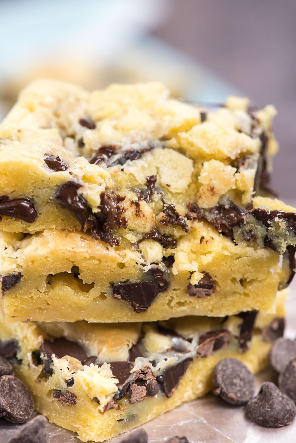 Stack of chocolate chip gooey cake bars with chocolate chips around the base