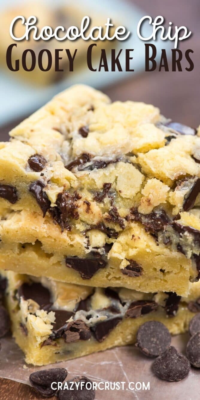 Stack of chocolate chip gooey cake bars with chocolate chips around the base with recipe title on top of image
