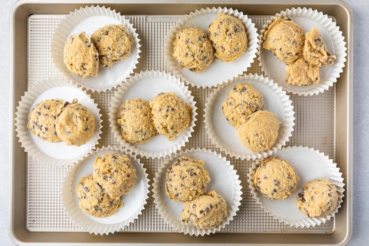 Overhead shot of num num cookie dough scoops in cookie cups on cookie sheet