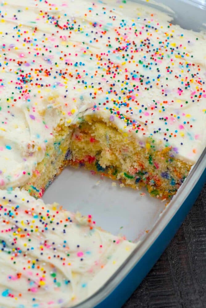 Homemade funfetti cake in cake pan with one square piece missing