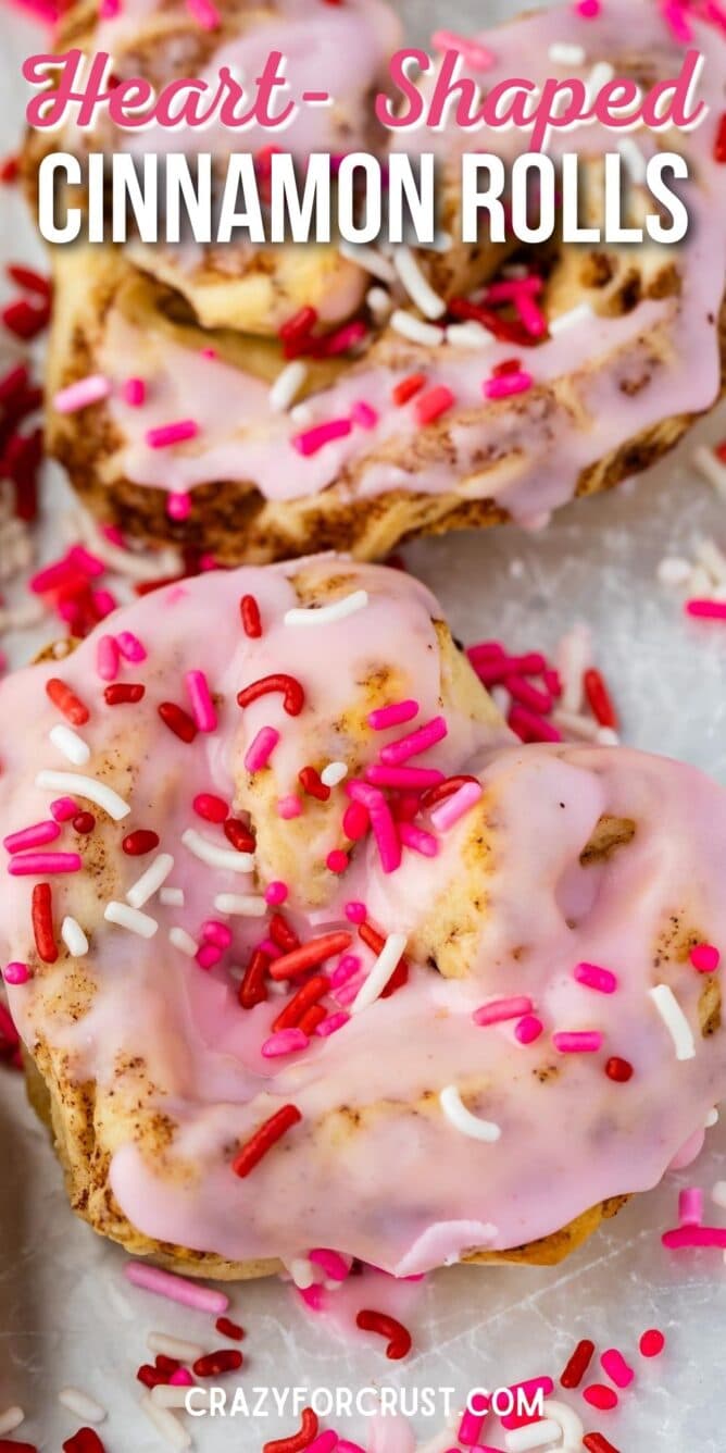 heart shaped cinnamon roll with pink icing and sprinkles