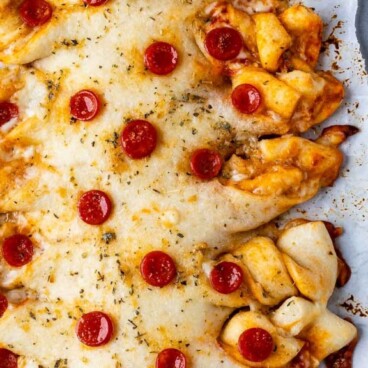Overhead shot of pull apart pepperoni pizza on a sheet pan with recipe title on top of image