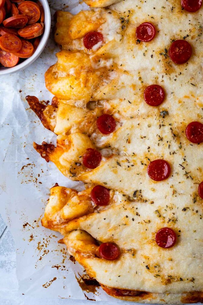 Close up overhead shot of twisted pepperoni pizza on a sheet pan