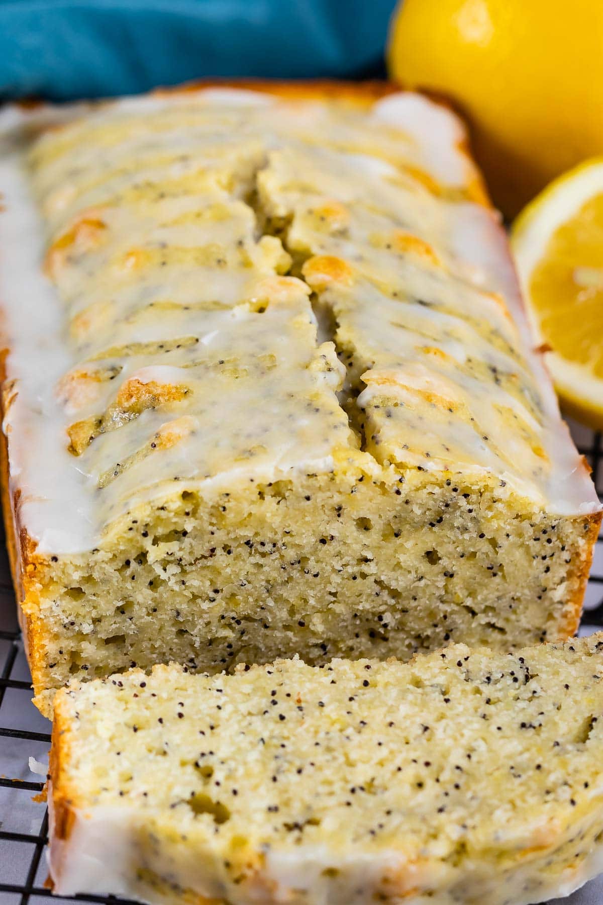 Lemon poppyseed bread loaf with one slice cut off and laid in front of loaf