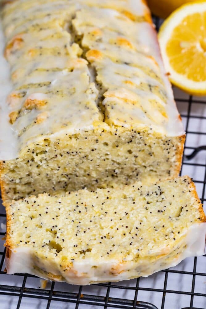 Lemon poppyseed bread loaf with one slice cut off and laid in front of loaf