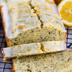 Lemon poppyseed bread loaf with two slices cut off and laid in front of loaf